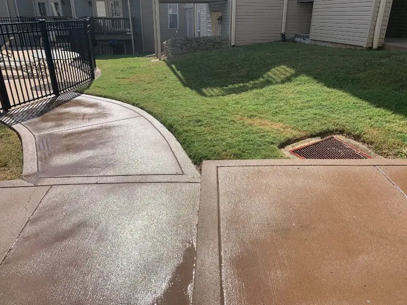 A concrete walkway in a residential community that has just been washed
