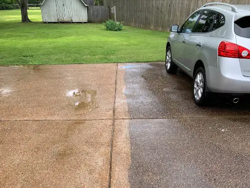 A concrete driveway that has been half washed to display the difference