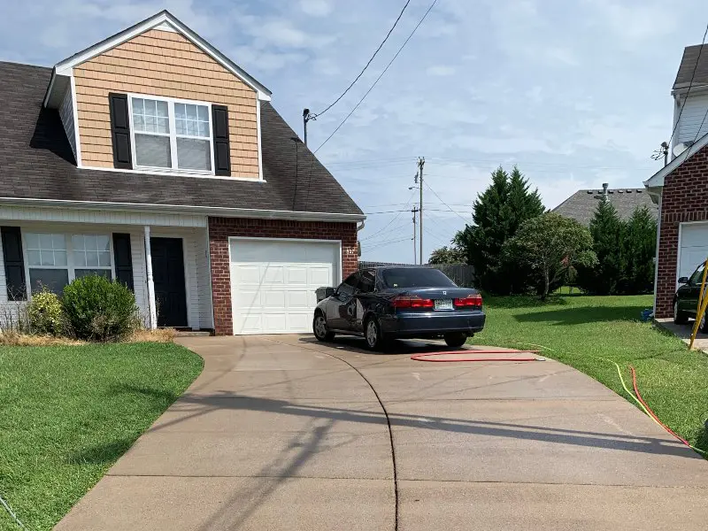 A long concrete driveway that has been professionally cleaned and sealed