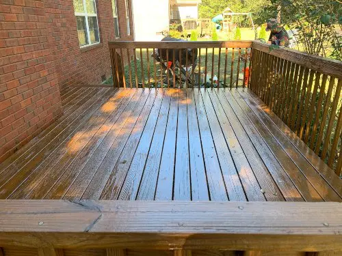 A wooden back deck that has been recently cleaned and stained