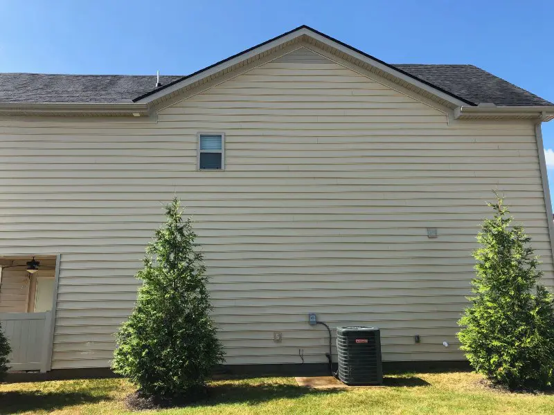 Dingy yellow siding on the side of a residential property