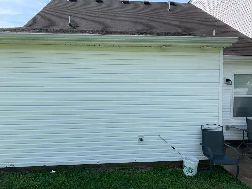 The side of a white house displaying recently washed panels