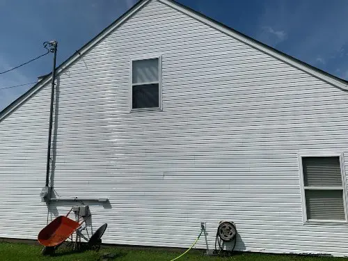 The side of a white home that has been pressure washed and has spotless panels